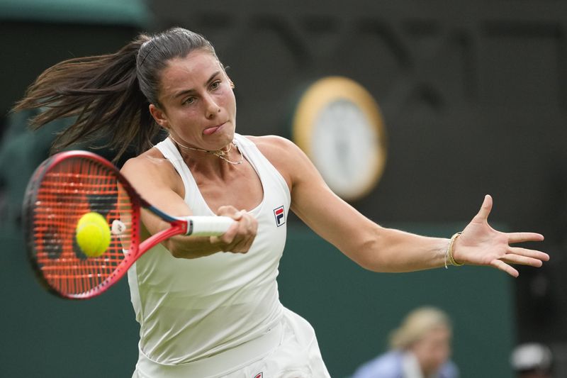 Emma Navarro of the United States plays a forehand return to Jasmine Paolini of Italy during their quarterfinal match at the Wimbledon tennis championships in London, Tuesday, July 9, 2024. (AP Photo/Alberto Pezzali)