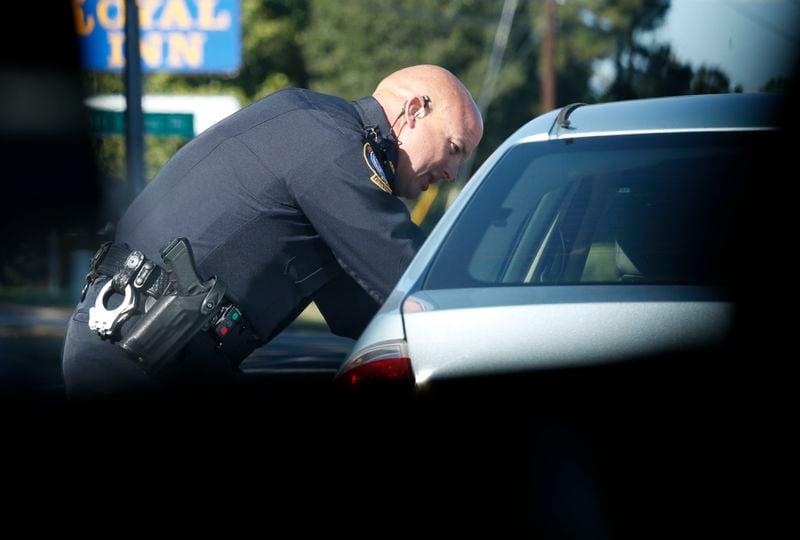 Oct. 20, 2015 - Jonesboro - Officer Perry stops a motorist for having no insurance, a violation flagged by the tag reader. Phillip Perry, shift senior officer and training officer for the Jonesboro police department, goes on traffic patrol with the department's license plate reader equipped patrol car. The license plate reader can scan cars as they pass and run their plates against a government database to check for violations. Within an hour, Perry had written two citations for vehicles without insurance coverage, one for expired registration, and impounded two cars. Most of the department's citations come from the license plate reader. BOB ANDRES / BANDRES@AJC.COM