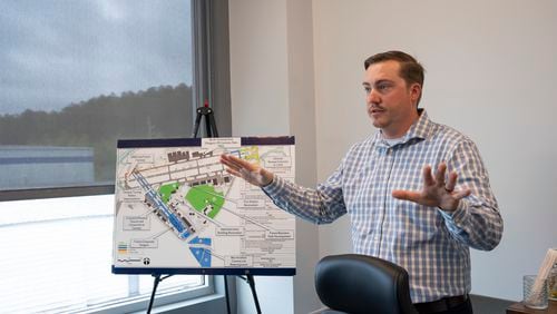 Jonathan Gauthier shows development plans on a map at the Fulton Executive Airport as part of a larger investment plan to renew Fulton Industrial Blvd in Atlanta, Georgia on Thursday, April 11, 2024. (Olivia Bowdoin for the AJC). 