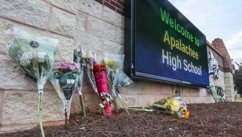 Flowers at the foot of the welcome sign to Apalachee High School for a makeshift memorial a day after two students and two teachers were gunned down. (John Spink/AJC)