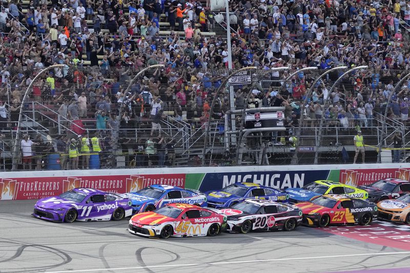 Denny Hamlin (11) and Tyler Reddick (45) lead the field on the green flag during a NASCAR Cup Series auto race at Michigan International Speedway, Sunday, Aug. 18, 2024, in Brooklyn, Mich. (AP Photo/Carlos Osorio)