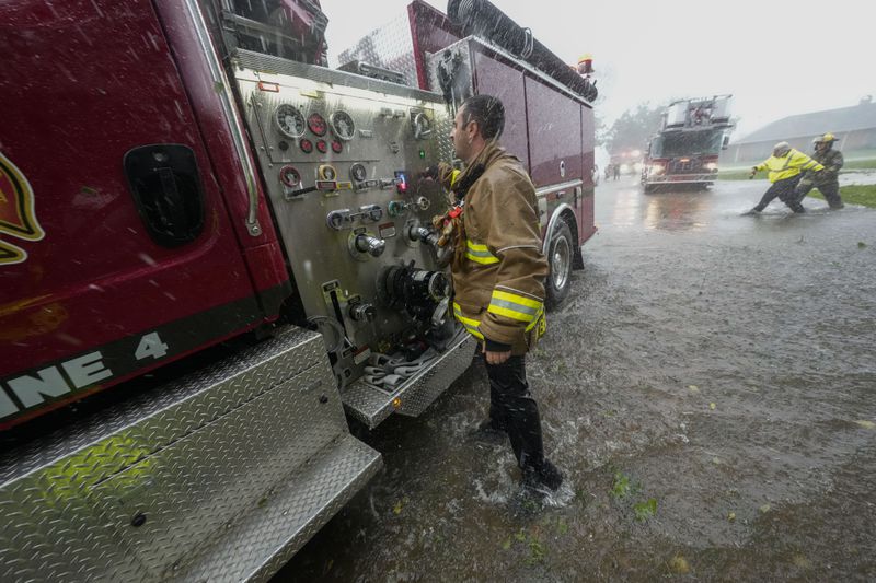 Morgan City firefighters respond to a home fire during Hurricane Francine in Morgan City, La., Wednesday, Sept. 11, 2024. (AP Photo/Gerald Herbert)