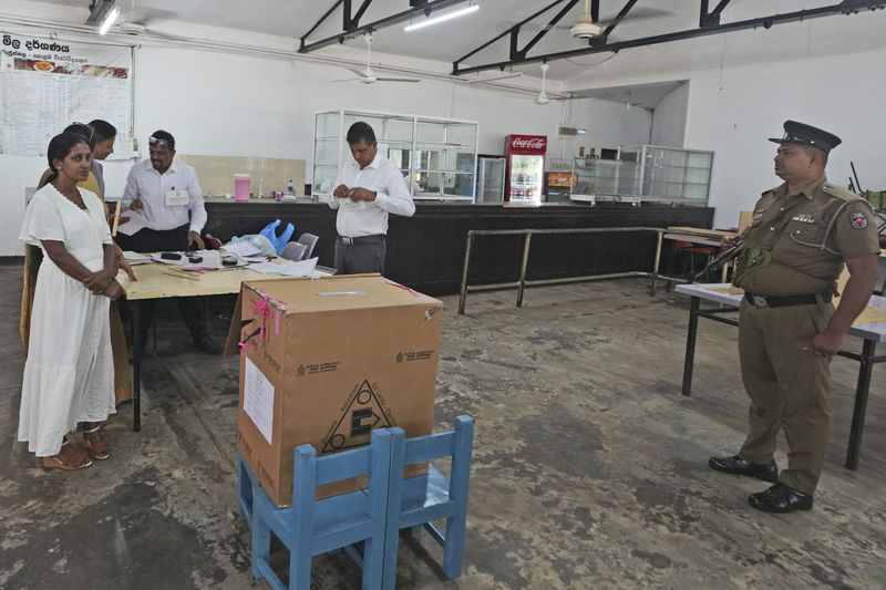 A police officer stands guard as polling officers set up their booth in Colombo, Sri Lanka, Saturday, Sept. 21, 2024. (AP Photo/Rajesh Kumar Singh)