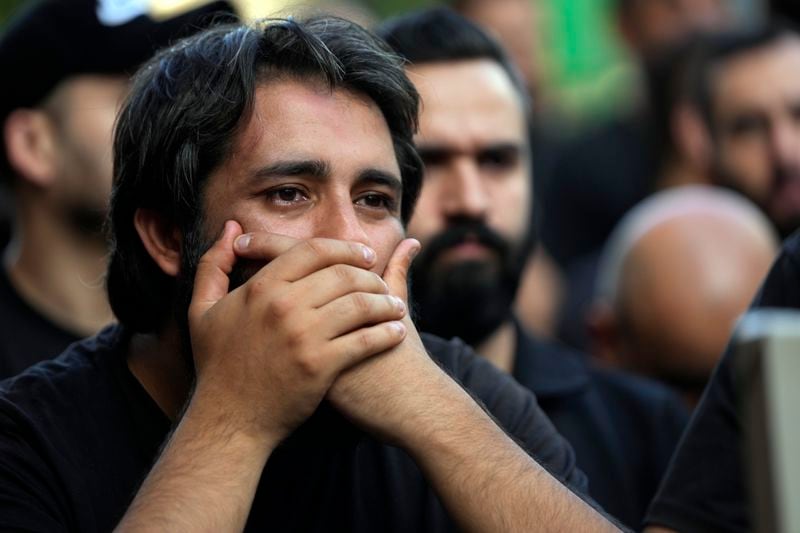 A man mourns during the funeral procession of two Hezbollah members, killed on Wednesday when a handheld device exploded, in the southern suburbs of Beirut, Thursday, Sept. 19, 2024. (AP Photo/Hussein Malla)