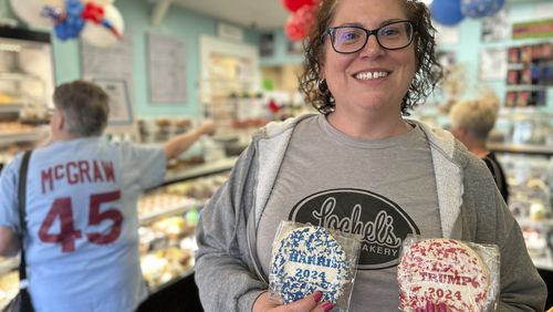 Bakery owner Kathleen Lochel holds sugar cookies, one with blue and white sprinkles and a Harris 2024 label on it and the other, with red and white sprinkles and a Trump 2024 label on it in Lochel Bakery, Tuesday, Sept. 24, 2024, in Hatboro, a suburb of Philadelphia. (AP Photo/Tassanee Vejpongsa)