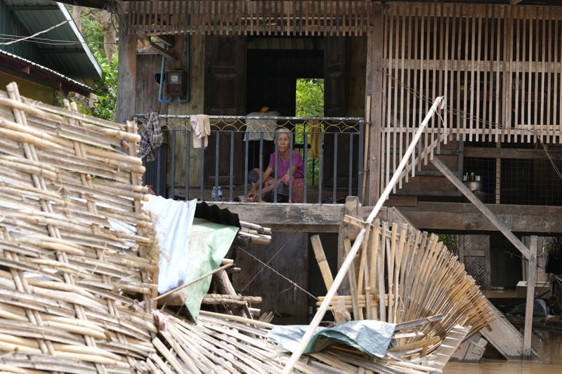 A women rests near a flooded road in Naypyitaw, Myanmar, Saturday, Sept. 14, 2024. (AP Photo/Aung Shine Oo)