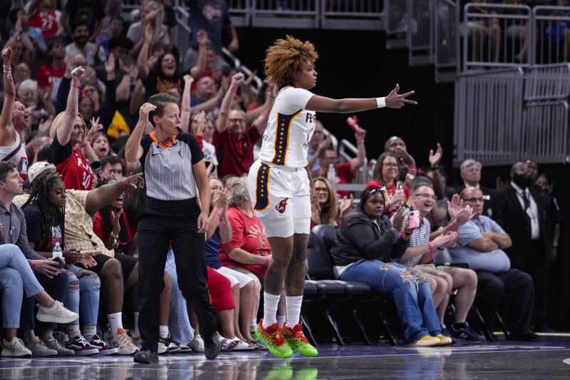 Indiana Fever forward NaLyssa Smith (1) celebrates a three-point basket against the Connecticut Sun in the first half of a WNBA basketball game in Indianapolis, Wednesday, Aug. 28, 2024. (AP Photo/Michael Conroy)