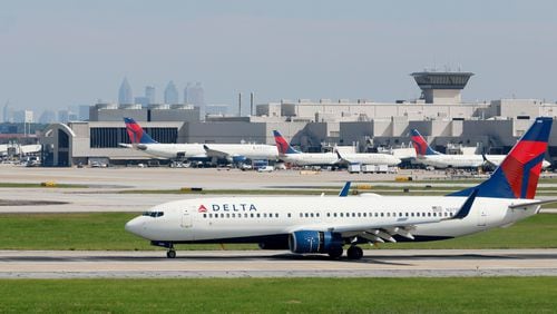 With the Atlanta skyline in the background, a Delta airplane lands at Hartsfield-Jackson International Airport on Sept. 7, 2022, in Atlanta. (Jason Getz/The Atlanta Journal-Constitution/TNS)
