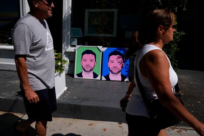 People walk past paintings of Justin Timberlake outside a gallery, Friday, Sept. 13, 2024, in Sag Harbor, N.Y. (AP Photo/Pamela Smith)