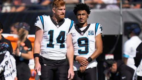 Carolina Panthers quarterbacks Andy Dalton (14) and Bryce Young (9) watches against the Chicago Bears during the first half of an NFL football game Sunday, Oct. 6, 2024, in Chicago. (AP Photo/Charles Rex Arbogast)