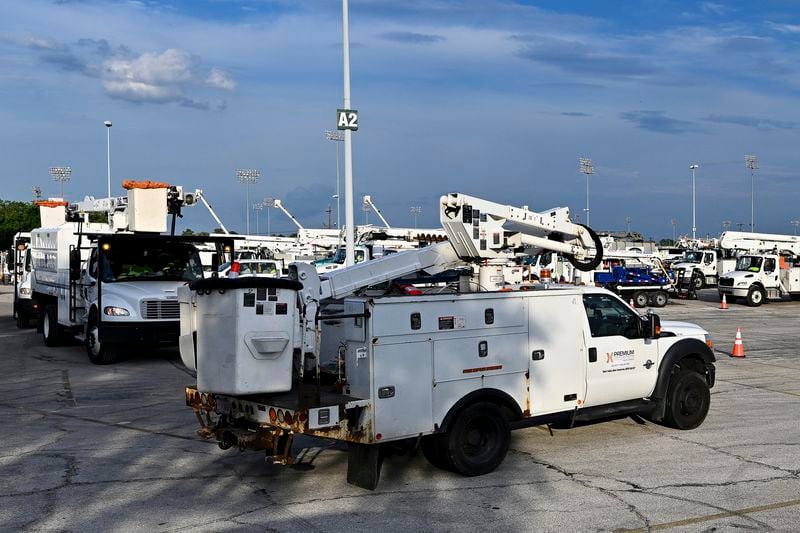 Utility trucks sit parked at a CenterPoint Energy staging center at the Houston Race Track in Houston, Wednesday, July 10, 2024. Millions of residents lost power after Hurricane Beryl made landfall. (AP Photo/Maria Lysaker)