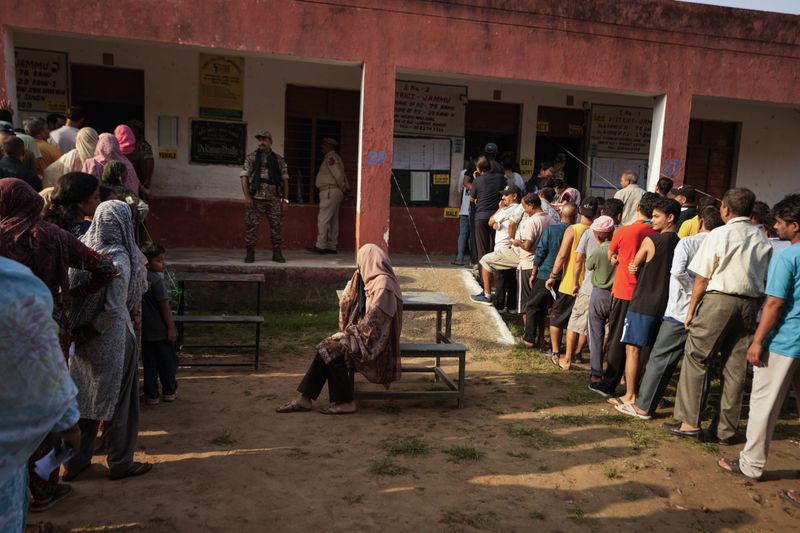 People queue up to cast their vote at a polling booth during the final phase of an election to choose a local government in Indian-controlled Kashmir in Jammu, India, Tuesday, Oct. 1, 2024. (AP Photos/Channi Anand)