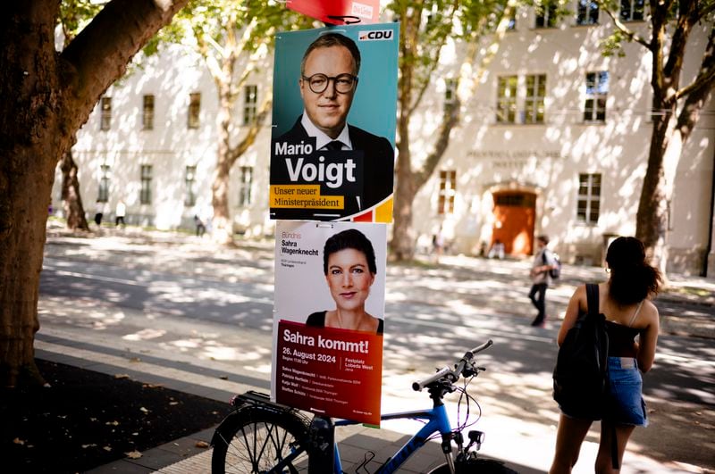 Election campaign posters of the Christian Democratic Union party, CDU, with top candidate Mario Voigt and of the Sahra Wagenknecht Alliance are displayed at a lamp post in Jena, Germany, Aug. 13, 2024. State elections in Thuringia and Saxony scheduled on Sunday Sept. 1, 2024, in the eastern Germany states. (AP Photo/Markus Schreiber)