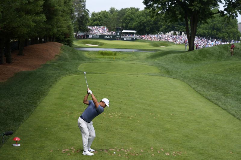 Tom Kim, of South Korea, tees off on the eighth hole during the final round of the Travelers Championship golf tournament at TPC River Highlands, Sunday, June 23, 2024, in Cromwell, Conn. (AP Photo/Seth Wenig)