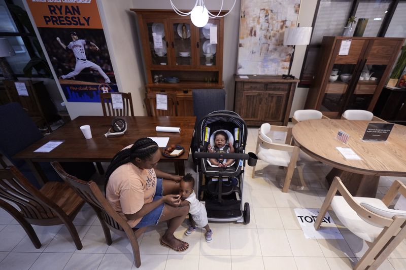 Houston resident Ashley Doyle and her children, Kaysen and Jayce, spend time at Gallery Furniture, which is being used as a temporary shelter, to cool off and and have a meal, Tuesday, July 9, 2024, in Houston. The effects of Hurricane Beryl left most in the area without power. (AP Photo/Eric Gay)