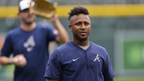 Injured Atlanta Braves second baseman Ozzie Albies heads back to the dugout after throwing before a baseball game against the Colorado Rockies, Friday, Aug. 9, 2024, in Denver. (AP Photo/David Zalubowski)