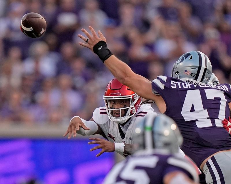 Arizona quarterback Noah Fifita passes around Kansas State defensive end Cody Stufflebean (47) during the first half of an NCAA college football game Friday, Sept. 13, 2024, in Manhattan, Kan. (AP Photo/Charlie Riedel)