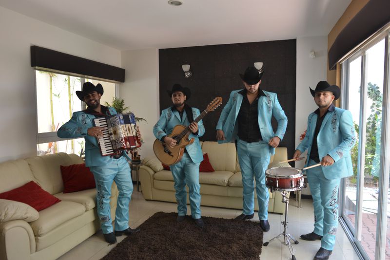 FILE - Members of "Los Varones de Culiacan" perform during an interview in their manager's home in Culiacan, Mexico, July 23, 2015. The band composed a song based on a prison escape by drug kingpin Joaquin "El Chapo" Guzman. (AP Photo/Fernando Brito, File)