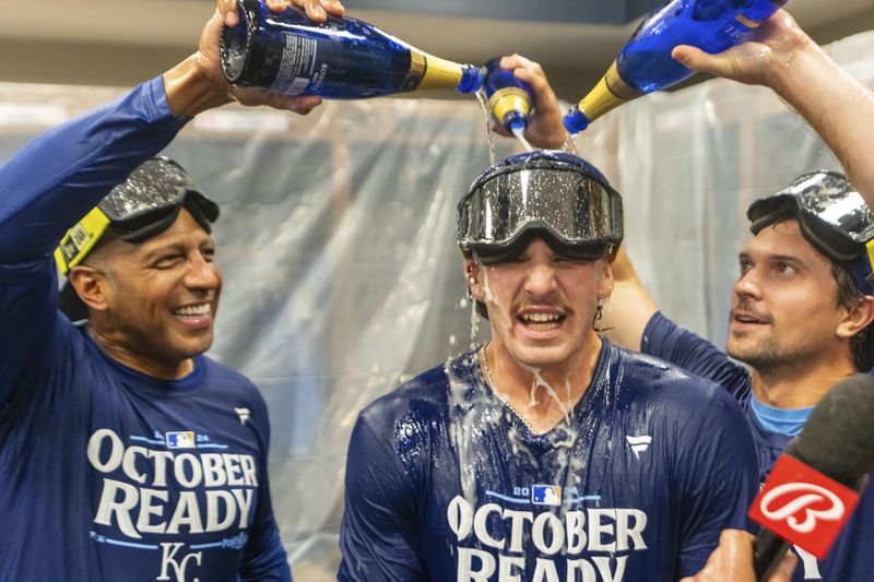 Kansas City Royals shortstop Bobby Witt Jr., center has champagne poured on him by teammates during the celebration in the locker room after a baseball game against the Atlanta Braves, Friday, Sept. 27, 2024, in Atlanta. (AP Photo/Jason Allen)