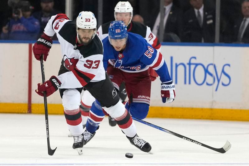 New Jersey Devils' Jakub Zboril, left, and New York Rangers' Will Cuylle, right, chase after the puck during the third period of an NHL preseason hockey game, Tuesday, Oct. 1, 2024, in New York. (AP Photo/Pamela Smith)