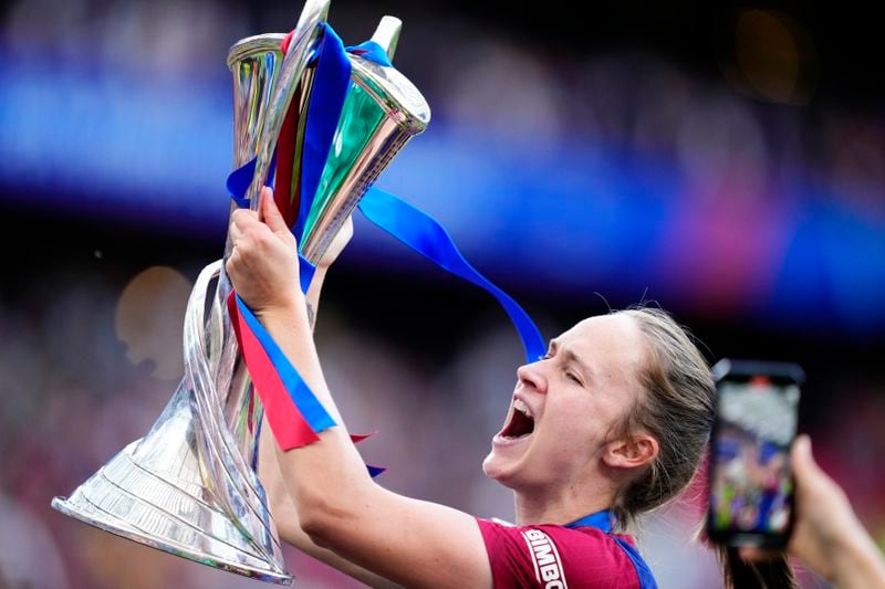 Barcelona's Caroline Graham Hansen celebrates with the trophy after winning the women's Champions League final soccer match between FC Barcelona and Olympique Lyonnais at the San Mames stadium in Bilbao, Spain, Saturday, May 25, 2024. Barcelona won 2-0. (AP Photo/Jose Breton)