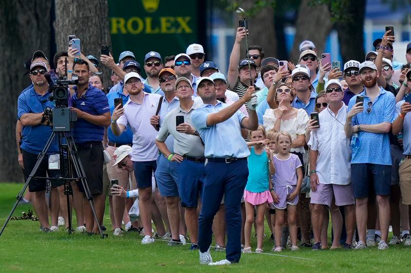 The gallery watches as Scottie Scheffler hits a shot on the seventh hole during the first round of the Charles Schwab Challenge golf tournament at Colonial Country Club, Thursday, May 23, 2024, in Fort Worth, Texas. (AP Photo/LM Otero)