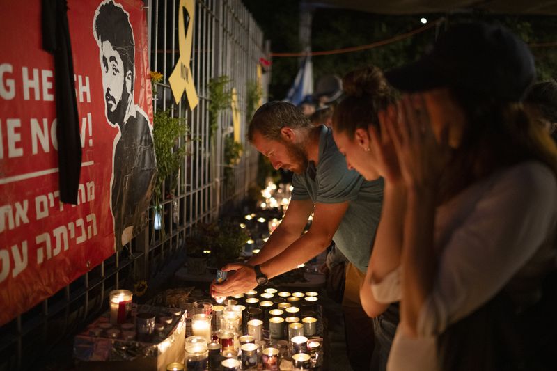 People light candles during a vigil in memory of slain hostage Hersh Goldberg-Polin in Jerusalem, Israel, Sunday, Sept. 1, 2024. (AP Photo/Leo Correa)