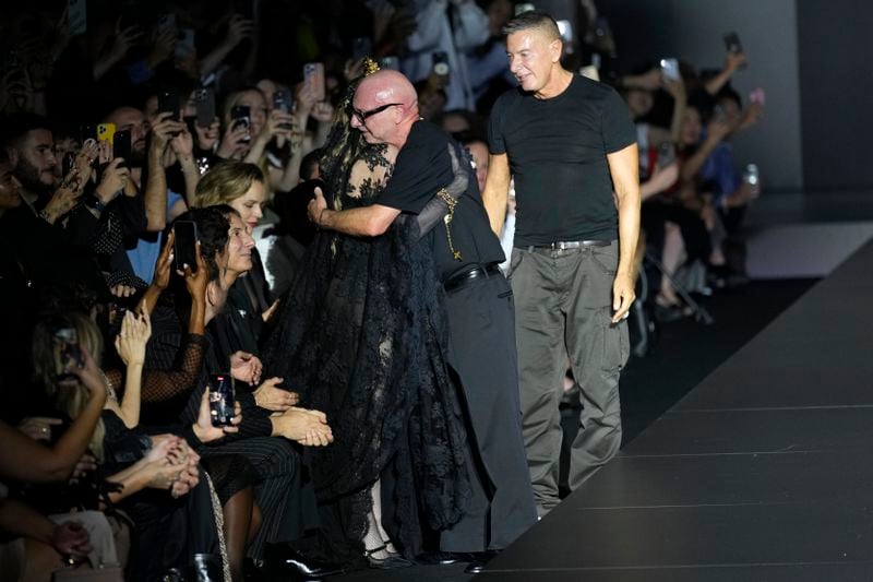 Italian designers Stefano Gabbana, right, and Domenico Dolce, centre, hug Madonna at the end of the Dolce & Gabbana Spring Summer 2025 fashion show, that was presented in Milan, Italy, Saturday, Sept. 21, 2024. (AP Photo/Antonio Calanni)