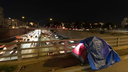 FILE - A tarp covers a portion of a homeless person's tent on a bridge overlooking the 101 Freeway in Los Angeles, Thursday, Feb. 2, 2023. (AP Photo/Jae C. Hong, File)