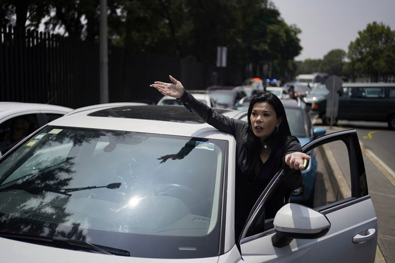 A commuter complains about a roadblock by law students protesting against constitutional reform proposals that would make judges stand for election, outside a sports center where lawmakers are meeting as an alternative due to other demonstrators blocking Congress in Mexico City, Tuesday, Sept. 3, 2024. (AP Photo/Felix Marquez)