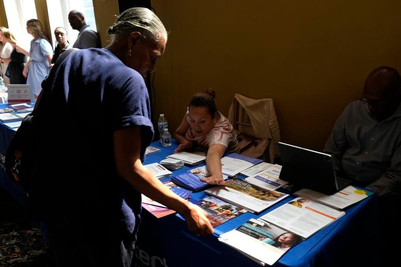 A woman shows different pamphlets at the Black Health Matters Health Summit and Expo in New York, Thursday, Aug. 15, 2024. (AP Photo/Pamela Smith)