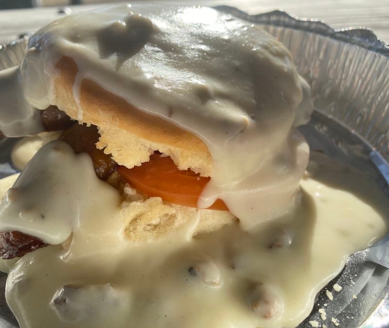 The Southern smothered biscuit at the Brunch Apothecary comes with a choice of meat, tomato slice and poached egg, all covered in gravy. Ligaya Figueras/ligaya.figueras@ajc.com
