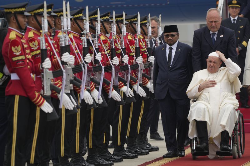 Pope Francis is welcomed by Indonesia's Minister for Religious Affairs Yaqut Cholil Qoumas, center, soon after landing at Jakarta's International airport Soekarno Hatta, Tuesday, Sept. 3, 2024. Pope Francis arrived in Indonesia on Tuesday at the start of the longest trip of his pontificate, hoping to encourage its Catholic community and celebrate the tradition of interfaith harmony in a country with the world's largest Muslim population. (AP Photo/Gregorio Borgia)