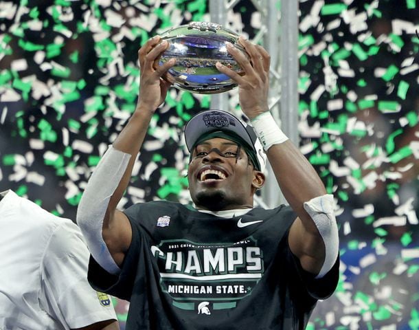 Michigan State Spartans wide receiver Jayden Reed hoists the trophy after their 31-21 win against the Pittsburgh Panthers during the Chick-fil-A Peach Bowl at Mercedes-Benz Stadium in Atlanta, Thursday, December 30, 2021. JASON GETZ FOR THE ATLANTA JOURNAL-CONSTITUTION