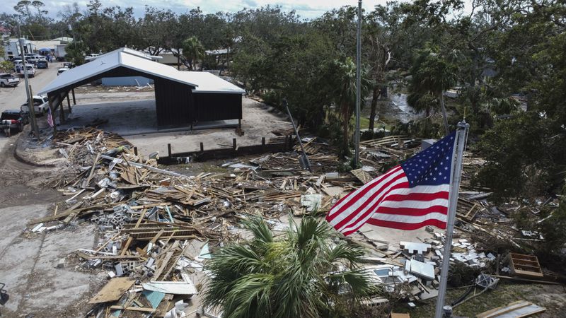 An American flag flies over the destroyed city hall in the aftermath of Hurricane Helene, in Horseshoe Beach, Fla., Saturday, Sept. 28, 2024. (AP Photo/Stephen Smith)