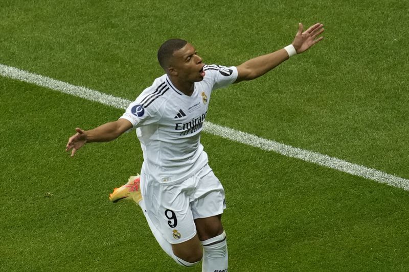 Real Madrid's Kylian Mbappe celebrates after scoring his side's second goal during the UEFA Super Cup Final soccer match between Real Madrid and Atalanta at the Narodowy stadium in Warsaw, Poland, Wednesday, Aug. 14, 2024. (AP Photo/Darko Vojinovic)