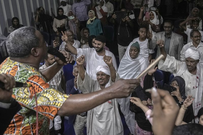 Sudanese Camirata troupe founder Dafallah el-Hag performs as Sudanese and foreign audience react during a show at the Russian culture center in Cairo, Egypt, Sunday, Sept. 15, 2024. (AP Photo/Amr Nabil)