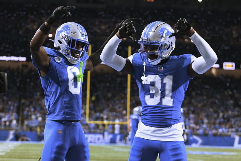 Detroit Lions safety Kerby Joseph (31) celebrates his interception with Detroit Lions cornerback Terrion Arnold (0) against the Los Angeles Rams during the first half of an NFL football game in Detroit, Sunday, Sept. 8, 2024. (AP Photo/David Dermer)