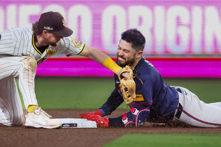 Atlanta Braves’ Travis d'Arnaud (16) slides safely into second base on a double as San Diego Padres’ Manny Machado (13) applies a late tag during the fourth inning of National League Division Series Wild Card Game One at Petco Park in San Diego on Tuesday, Oct. 1, 2024.   (Jason Getz / Jason.Getz@ajc.com)