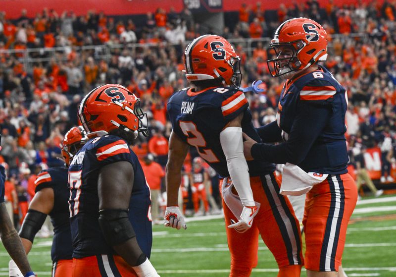 Syracuse wide receiver Trebor Pena (2) and quarterback Kyle McCord (6) celebrate a touchdown with teammates during the first half of an NCAA football game against Georgia Tech, Saturday, Sept. 7, 2024, in Syracuse, N.Y. (AP Photo/Hans Pennink)