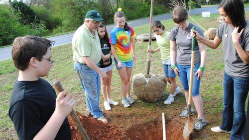 Milton City Arborist Mark Law supervises students during a previous Arbor Day tree planting. The city has honored Law by naming its new arboretum after him. CITY OF MILTON