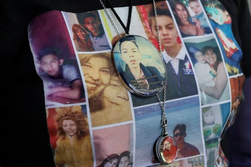 Photos of Veronica Rosas and her son Diego decorate Veronica's shirt and necklaces, as she poses for a portrait at her home in Ecatepec, Mexico, Friday, Aug. 2, 2024. Rosas' son went missing when he was 16 years old on Sept. 4, 2015. (AP Photo/Ginnette Riquelme)