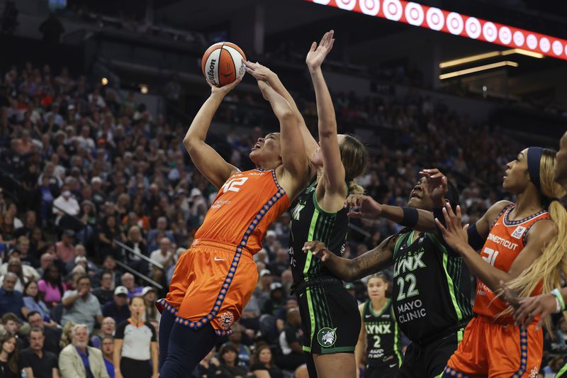 Connecticut Sun forward Brionna Jones (42) tries to make a basket against Minnesota Lynx forward Alanna Smith (8) during the second half of Game 1 of a WNBA basketball semifinals series Sunday, Sept. 29, 2024, in Minneapolis. (AP Photo/Stacy Bengs)