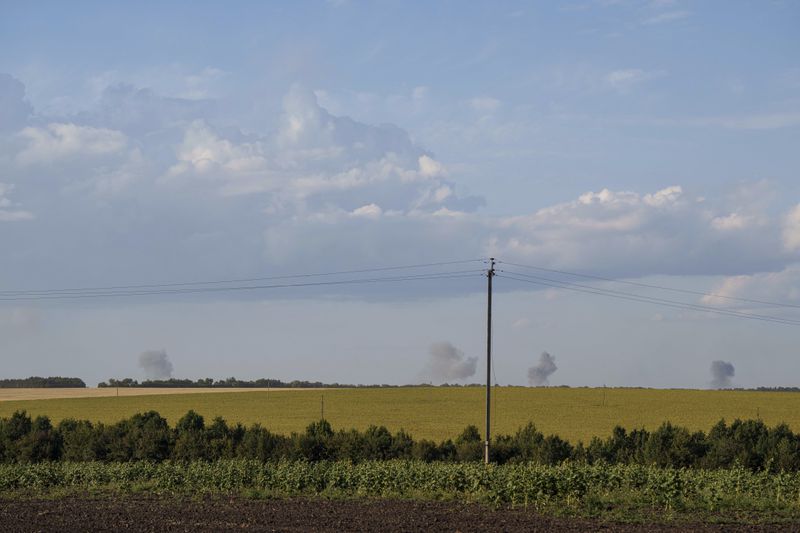 Explosions are seen in the horizon after Russian airstrikes near the Russian-Ukrainian border in Sumy region, Ukraine, Thursday, Aug. 15, 2024. (AP Photo/Evgeniy Maloletka)