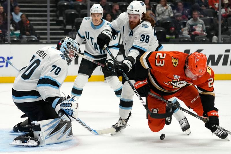 Anaheim Ducks center Mason McTavish, right, and Utah Hockey Club center Liam O'Brien, second from right, battle for the puck in front on goaltender Karel Vejmelka, left, during the first period of an NHL preseason hockey game, Wednesday, Oct. 2, 2024, in Anaheim, Calif. (AP Photo/Mark J. Terrill)