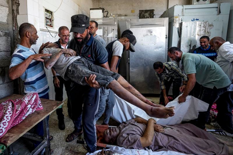 Palestinians mourn relatives killed in the Israeli bombardment of the Gaza Strip, at a hospital in Deir al-Balah, Tuesday, Aug. 27, 2024. (AP Photo/Abdel Kareem Hana)