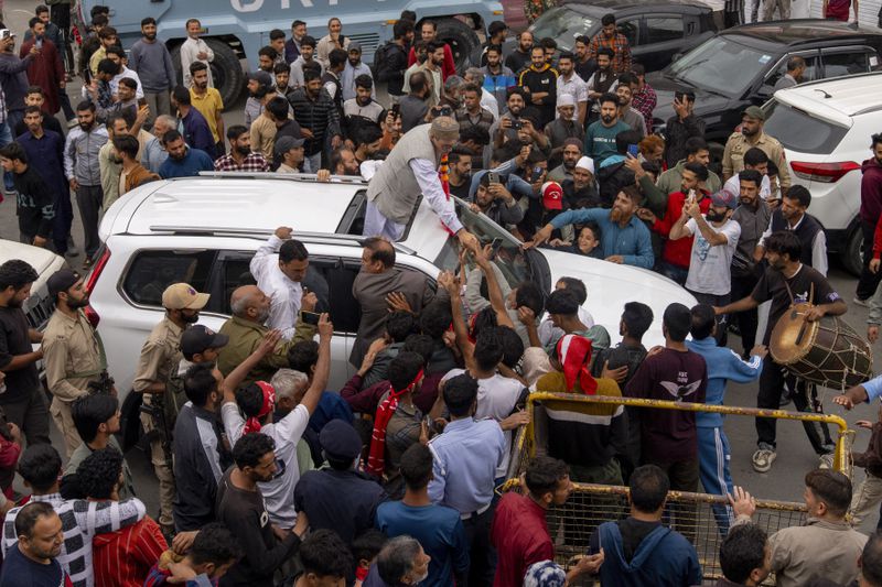 Jammu and Kashmir National Conference (JKNC) party leader Omar Abdullah, standing on car shakes hands with supporters as he celebrates his victory in the election for a local government in Indian controlled Kashmir, Budgam, Tuesday, Oct. 8, 2024. (AP Photo/Dar Yasin)