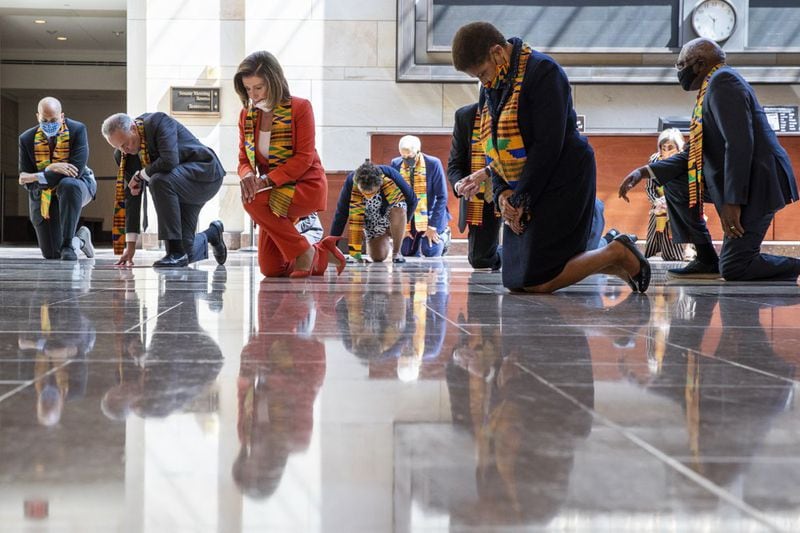 House Speaker Nancy Pelosi of Calif., center, and other members of Congress, kneel and observe a moment of silence at the Capitol's Emancipation Hall, Monday, June 8, 2020, on Capitol Hill in Washington, reading the names of George Floyd and others killed during police interactions. Democrats proposed a sweeping overhaul of police oversight and procedures Monday. (AP Photo/Manuel Balce Ceneta)