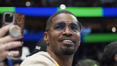 Jamie Foxx smiles during an NBA basketball game between the Washington Wizards and Dallas Mavericks in Dallas, Saturday, Nov. 27, 2021. Academy Award winning actor, Grammy winning singer and comedian says he “went to hell and back” but is recovering from an undisclosed medical condition. Foxx made his first public comments in an Instagram message posted on Friday, July 21, 2023 after being hospitalized in April.   (AP Photo/LM Otero, File)