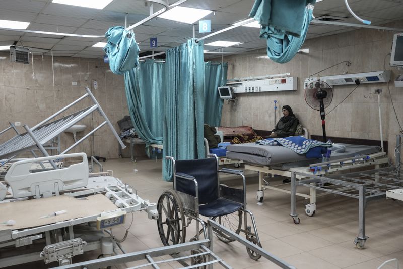 A woman sits on a bed in a room of the Al-Aqsa Martyrs hospital in Deir al Balah, Gaza Strip, Sunday, Aug. 25, 2024. (AP Photo/Abdel Kareem Hana)